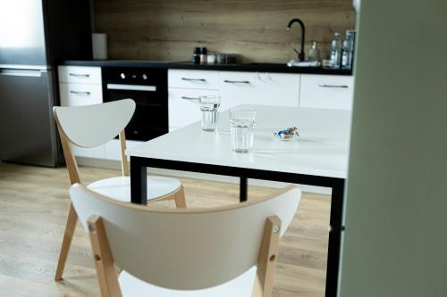 罗兹Brzeska 22的厨房配有白色桌子和白色椅子