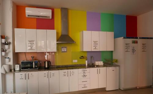 马略卡岛帕尔马帕尔马港旅舍 - 青年旅舍的厨房配有白色橱柜和色彩缤纷的墙壁