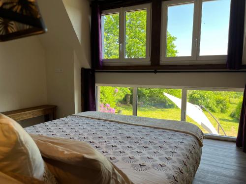 Les Portes du CoglaisMaison d'hôte avec sauna et jacuzzi à la campagne的一间卧室设有一张床和一个大窗户
