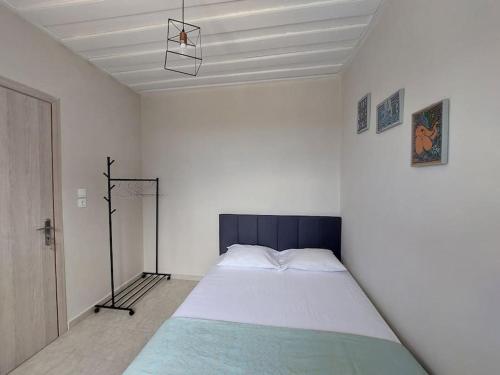 凯法利尼亚岛Giannata House的一间白色客房内配有一张大床的卧室