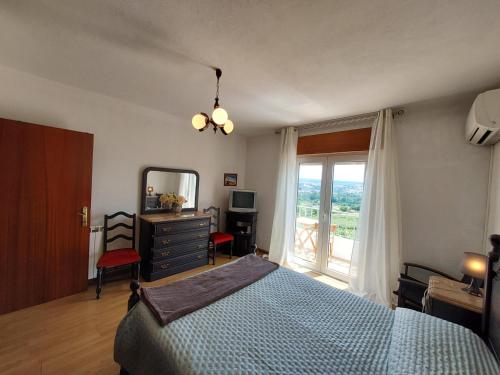 维拉·雷阿尔Casa Machado的一间卧室配有一张床、镜子和窗户