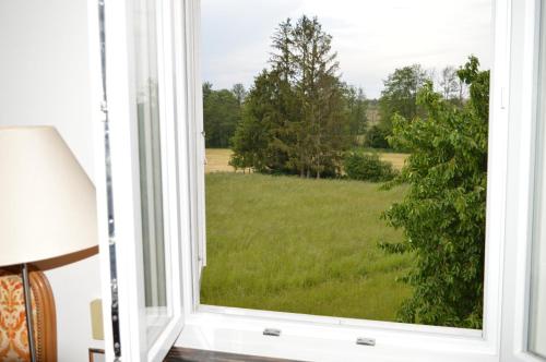 Chez Thérèse et Marguerite的享有草地景致的开放式窗户