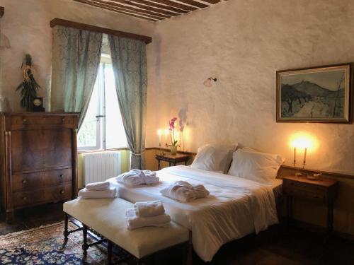 MontangesDomaine du Très-Haut - Château de Montanges的一间卧室配有带毛巾的床