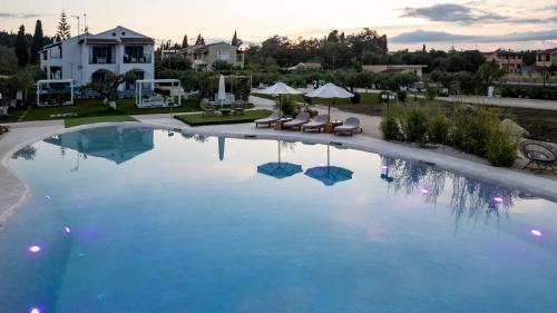 MelíkiaSun 'n Chill, Boutique Apartments & Beach Villa的一座房子前面的蓝色海水大型游泳池