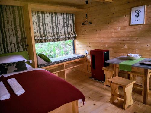 科巴里德Mountain lodge Forte Emilia的小木屋的卧室,配有一张床和一个窗户