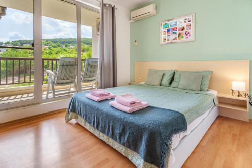 罗格其维Villa Poesia, Harmony Hills Residence的一间卧室配有一张床,上面有两条粉红色的毛巾