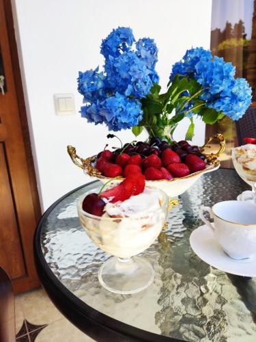 古达乌塔Diamond Eco Hotel的一张桌子,上面放着两碗水果和蓝色的鲜花