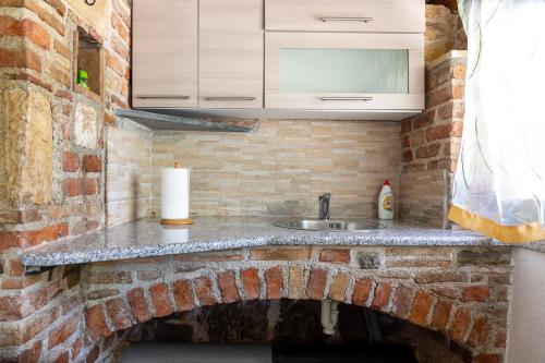 罗维尼Holiday house Hana的厨房设有水槽和砖墙
