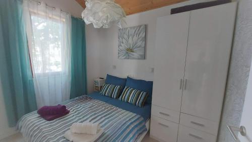 PotocnicaNavalia的卧室配有蓝色和白色的床和吊灯。