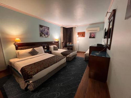 开罗开罗桑塔纳酒店的酒店客房设有两张床和电视。