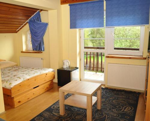 波拉齐克Ośrodek Wypoczynkowy CRYSTAL的卧室配有床、桌子和窗户。