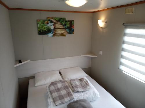 斯莫尔德兹诺Chillout的一间小卧室,配有白色的床和两个枕头