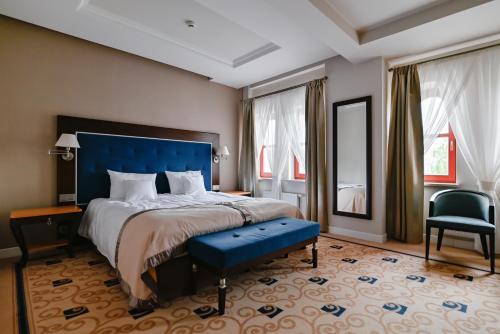 奥尔什丁Villa Garden Dyplomat的一间卧室配有一张大床和蓝色床头板