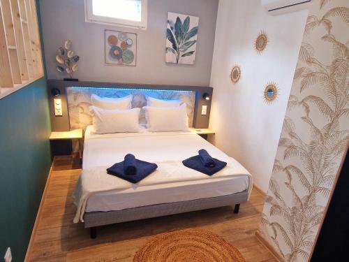 圣丹尼斯Le Platinium Barachois的一间卧室配有一张带蓝色毛巾的床