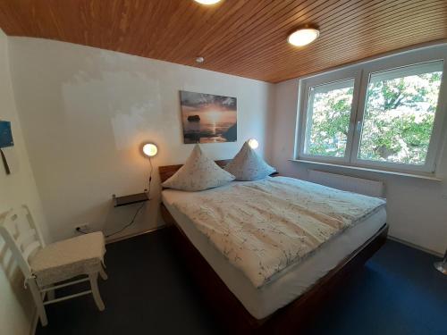 巴特施瓦尔陶Ferienwohnung im Zentrum的一间卧室配有一张床和一把椅子,还有两个窗户