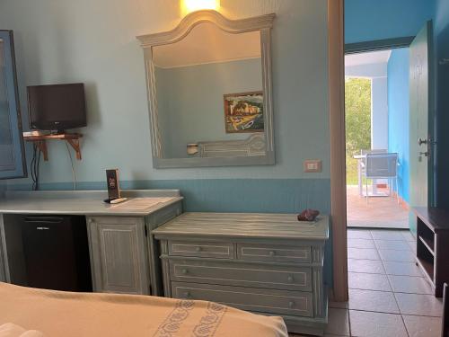 巴里萨尔多拜亚塞酒店的一间带镜子、梳妆台和床的卧室