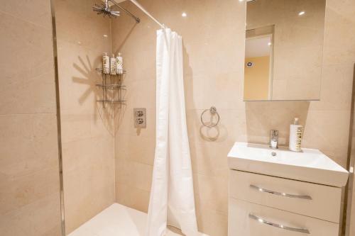Stone GroveLondon VEGETARIAN Smoke & Pet Free En-suite with EV parking的浴室配有淋浴帘和盥洗盆。