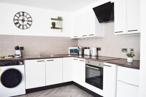 利物浦City Center Apartments FREE PARKING的白色的厨房配有白色橱柜和洗碗机。