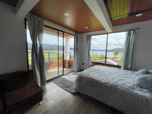 瓜塔维塔Hotel Villa Blanca Guatavita的一间卧室设有一张床和一个大窗户