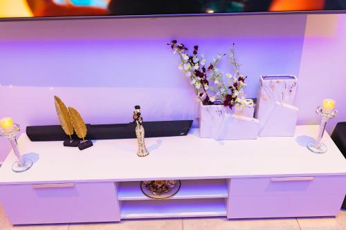 阿克拉Piano and Gold at The Signature, Tetteh Quarshie的紫色的桌子上放着花瓶