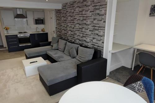 绍瑟姆Cosy 1 Bedroom Flat in Southam的带沙发和砖墙的客厅