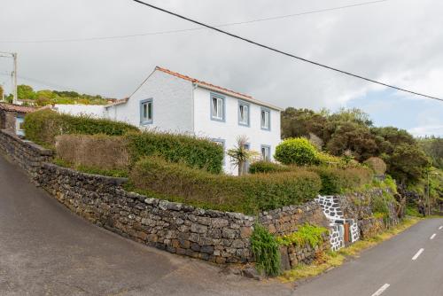 Calheta de NesquimLobo do Mar的石墙与街道上的房屋