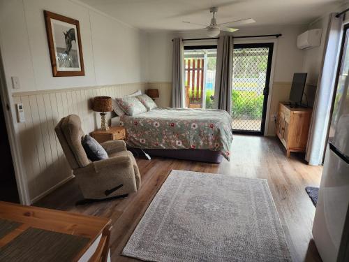 史丹霍普Spencer Lane Cottage & Granny Flat的卧室配有床、椅子和窗户。