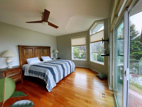 基洛纳湖景加花园景豪华别墅的一间卧室配有一张床和吊扇