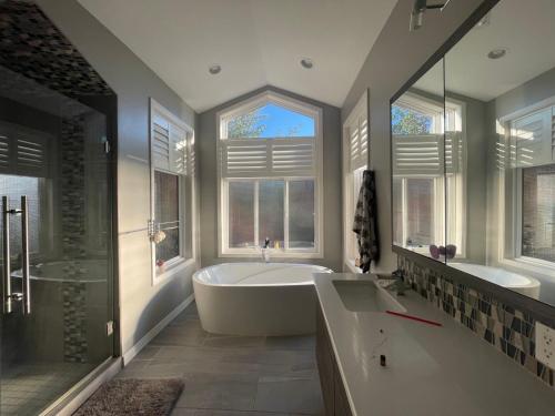 基洛纳湖景加花园景豪华别墅的带浴缸的大浴室和2扇窗户。