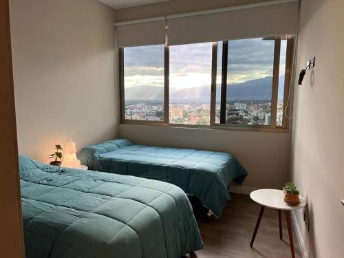 科恰班巴Depto a estrenar increíble vista 180º Cocha的一间卧室设有两张床和大窗户
