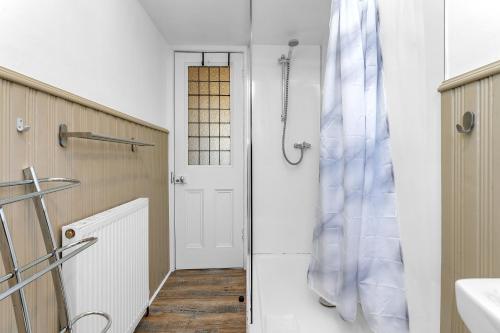 爱丁堡Marchmont Traditional Apartments的带淋浴的浴室和白色门