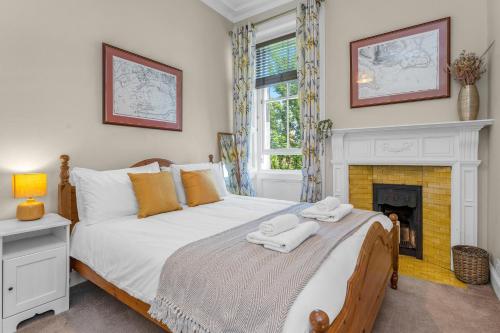 爱丁堡Marchmont Traditional Apartments的一间卧室配有一张床和一个壁炉