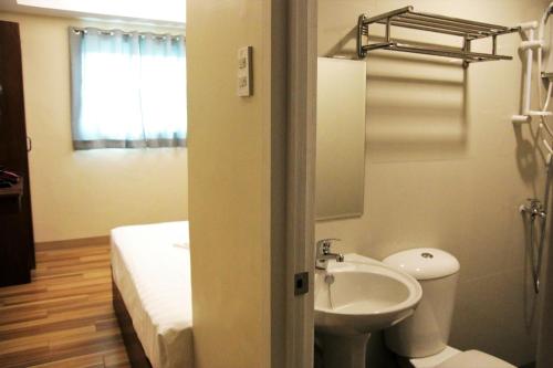 第波罗Happytelle的一间带水槽和卫生间的浴室以及一张床