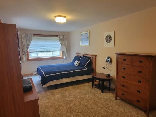 西南港Kenway Ranch的一间卧室配有蓝色的床和梳妆台