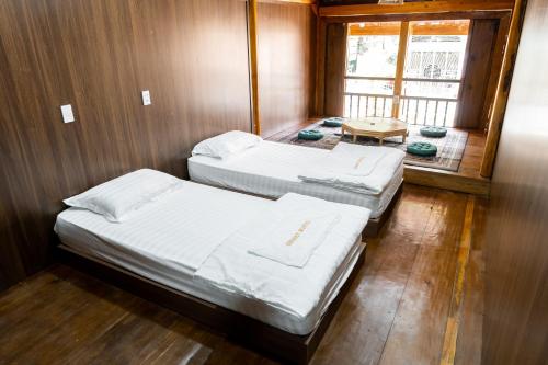 河江Odyssey Hostel, Tours & Motorbikes Rental的小型客房 - 带2张床和窗户