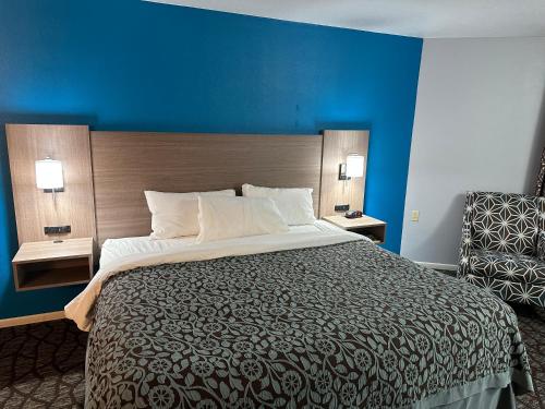 马尼斯蒂Baymont by Wyndham Manistee的一间卧室设有一张大床和蓝色的墙壁