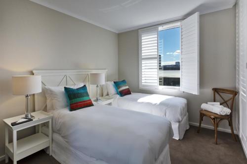 墨尔本StayCentral - Cityside on Whiteman Street Southbank的带窗户的客房内的2张白色床