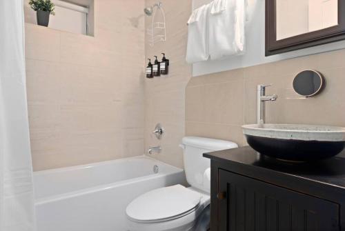 华盛顿Upscale 2BR Apartment with Patio的浴室配有盥洗盆、卫生间和浴缸。