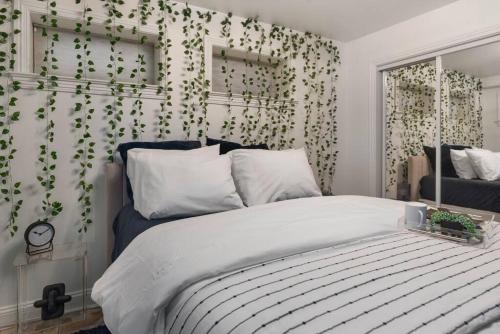 华盛顿Upscale 2BR Apartment with Patio的卧室配有一张挂着绿叶的墙壁床。