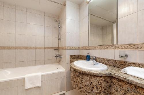 迪拜Luxury Princess Tower 1 Br Brand New Furnished apartment的浴室配有盥洗盆和浴缸。