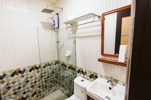 美岸Vigan Traversa Hotel的带淋浴、卫生间和盥洗盆的浴室