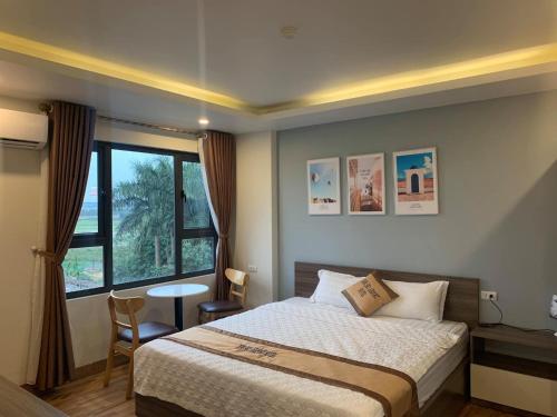 内排NEW SKY AIRPORT HOTEL NỘI BÀI的一间卧室配有一张床、一张桌子和一个窗户。
