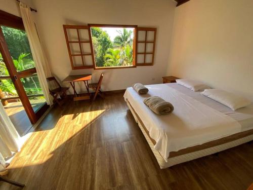 圣塞巴斯蒂安Ycatu Beach House的一间卧室设有一张大床和一个大窗户