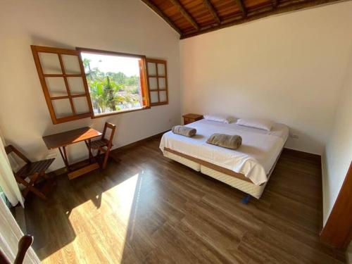 圣塞巴斯蒂安Ycatu Beach House的一间卧室设有一张床、一个窗口和一张桌子