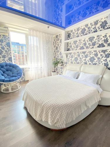 切尔诺夫策Zoryaniy Apartments City ПРОСТОРА та затишна НОВОБУДОВА біля парку Шевченка та ЦЕНТРУ的卧室配有白色大床和蓝色的墙壁