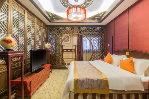 北京金龙建国温泉酒店的一间酒店客房,配有一张床和一台电视
