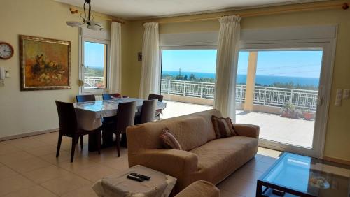 亚历山德鲁波利斯Magnificent View Villa的带沙发和桌子的客厅以及大窗户。