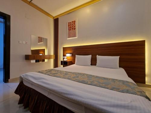 布赖代Shams Alshate شمس الشاطئ的一间卧室配有一张大床和木制床头板