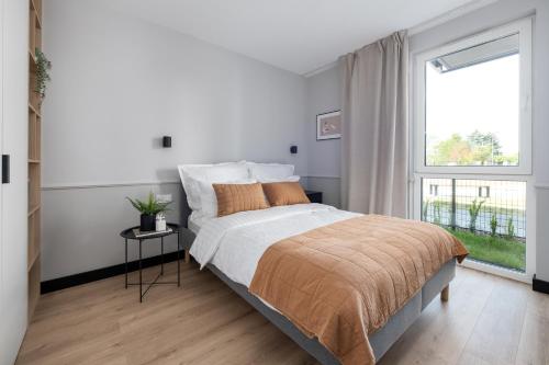 格但斯克A Morze Las - apartament na Wyspie Sobieszewskiej的白色的卧室设有一张大床和一个窗户