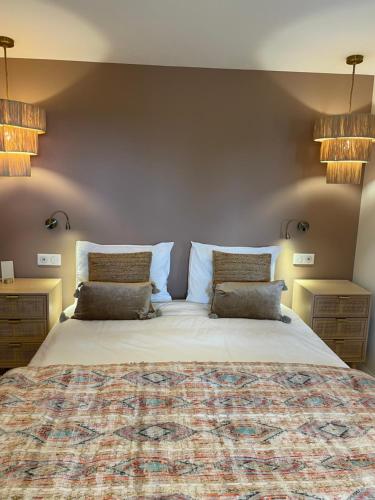 罗科福尔雷潘Villa La Carpenée的一间卧室配有一张大床和两个枕头
